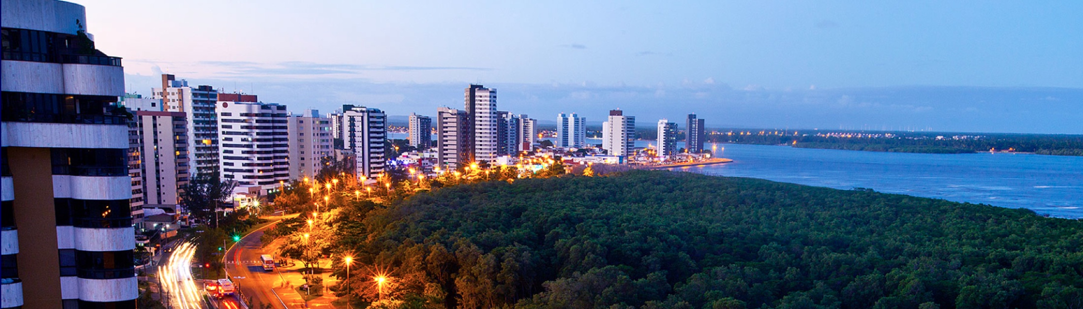 Vista urbana de Aracaju com orla e edifícios ao entardecer